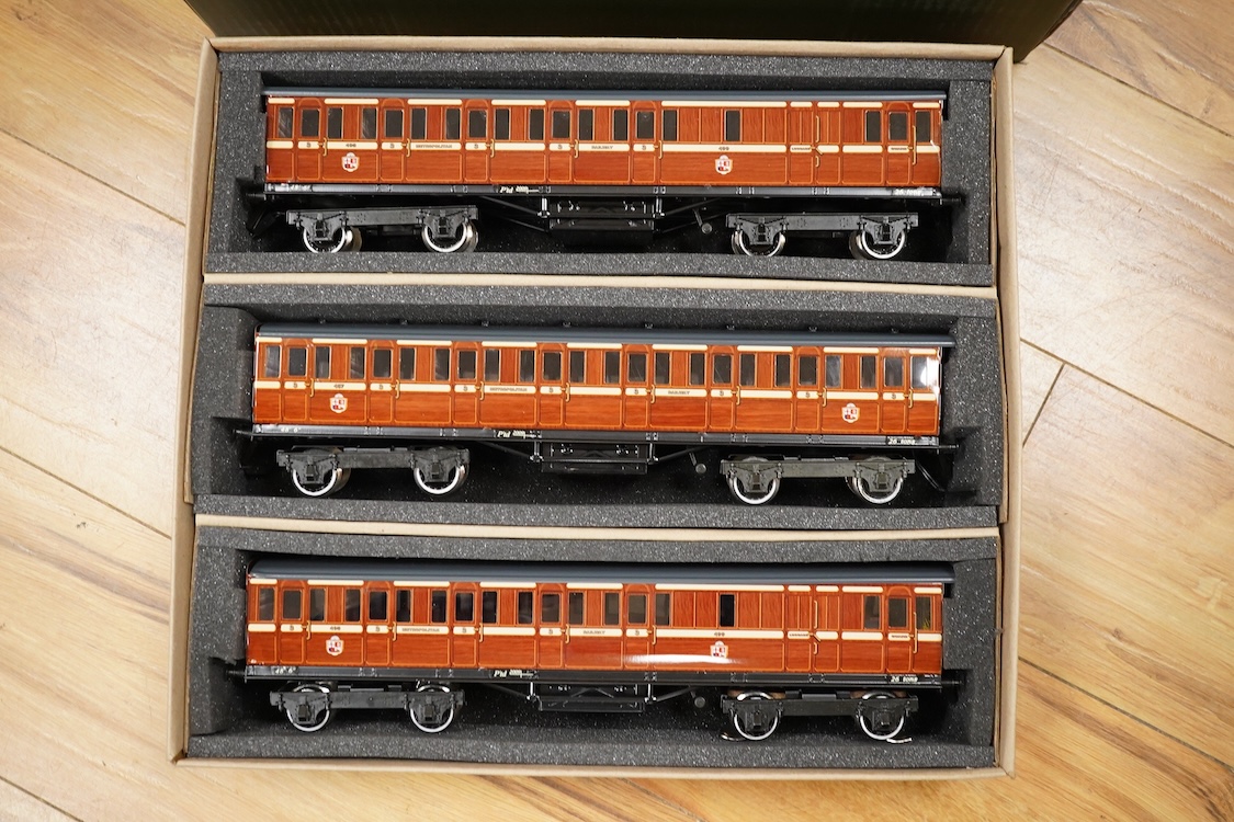 A boxed 0 gauge Darstaed tinplate Metropolitan Railway set of bogie coaches, a rake of five coaches in teak livery including; two Brake Thirds, two Full Thirds, and a Full First, fitted with internal lighting throughout